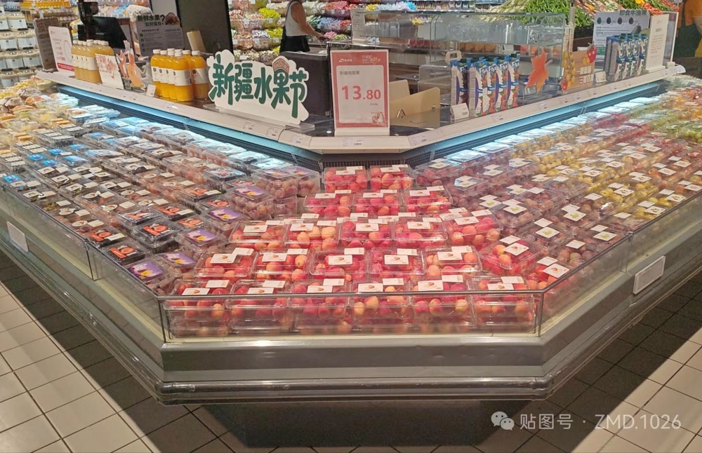 超市水果岛柜：满陈列的预包装水果、新疆水果节主题堆头与鲜榨果汁